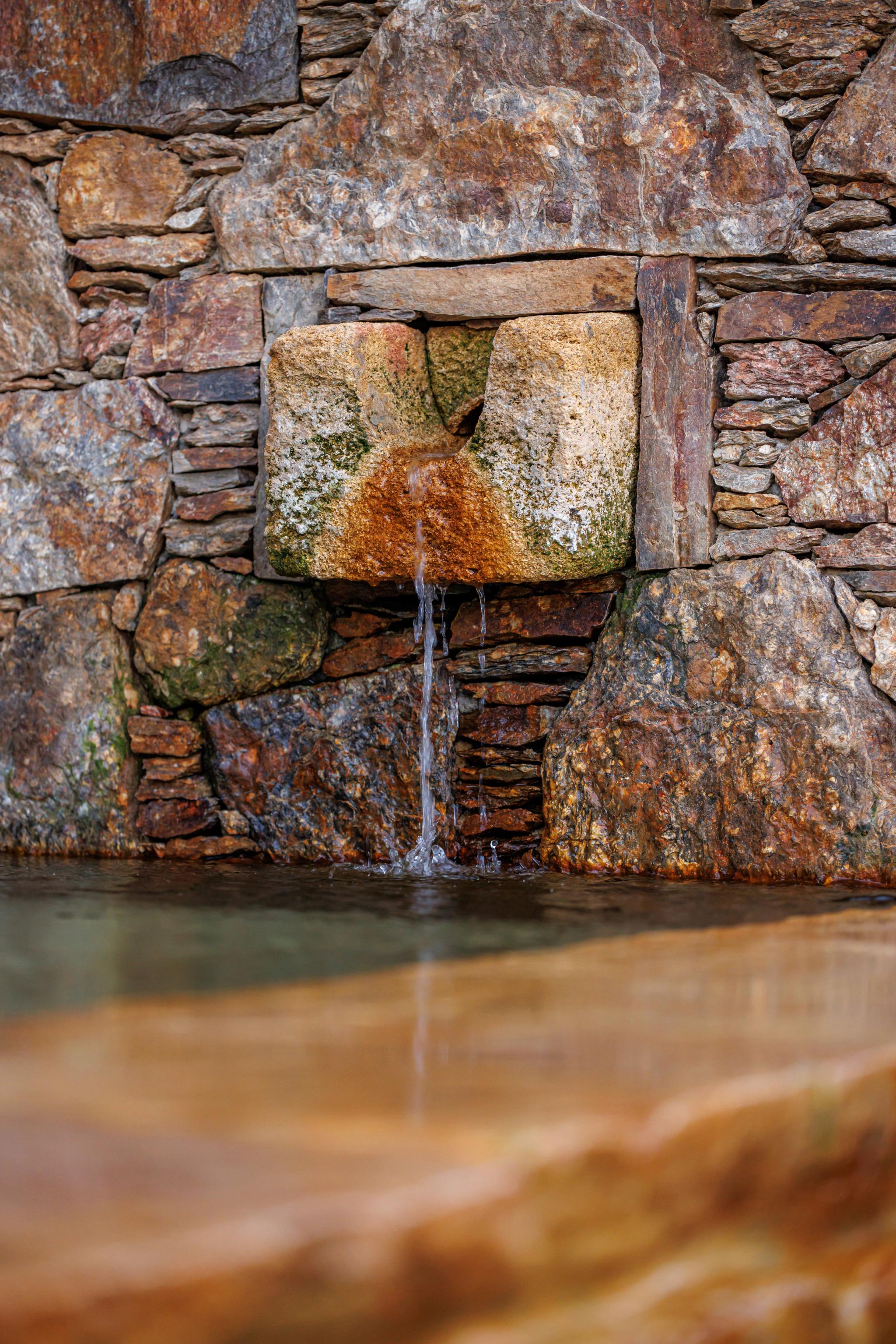 Fontaine à eau qui coule dans une piscine aux Oliviers de Palombaggia en Corse-du-Sud.