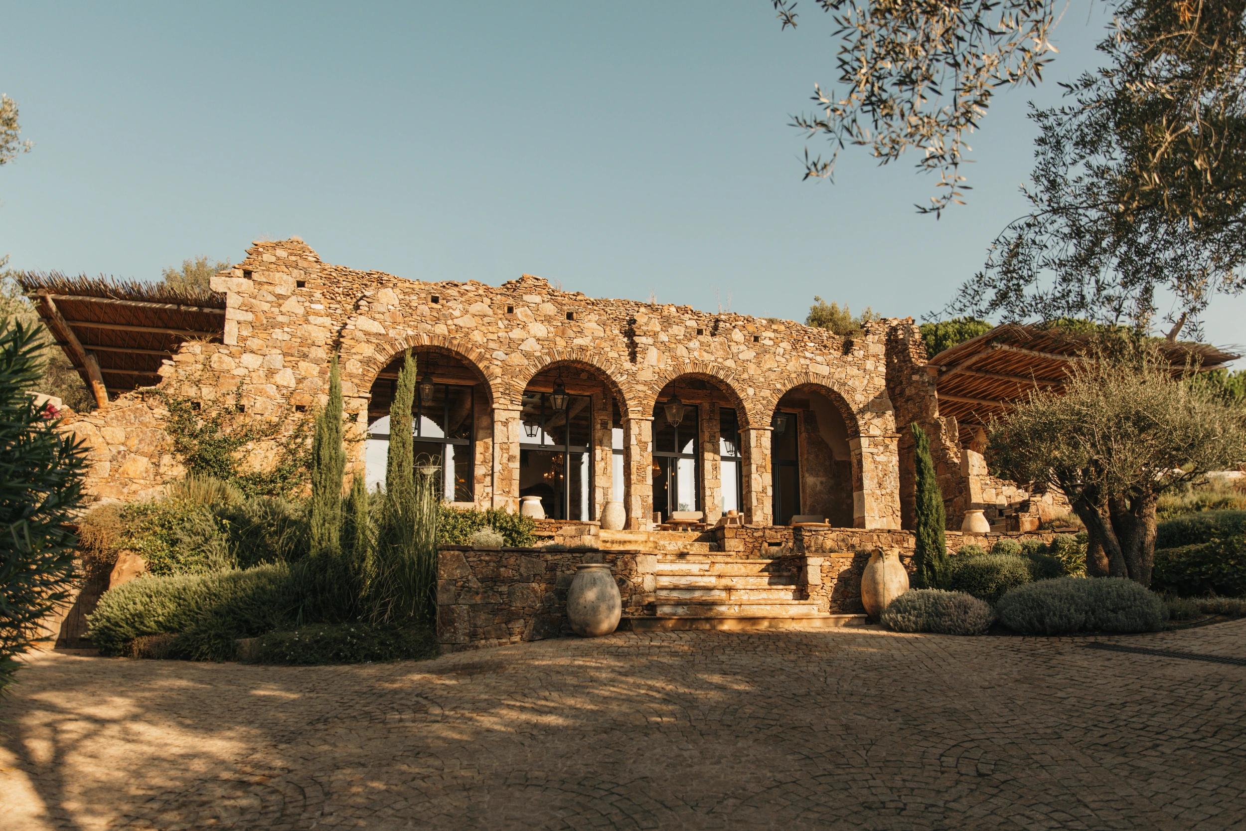 Grande entrée en pierre avec espace vert à côté aux Oliviers de Palombaggia en Corse-du-Sud.