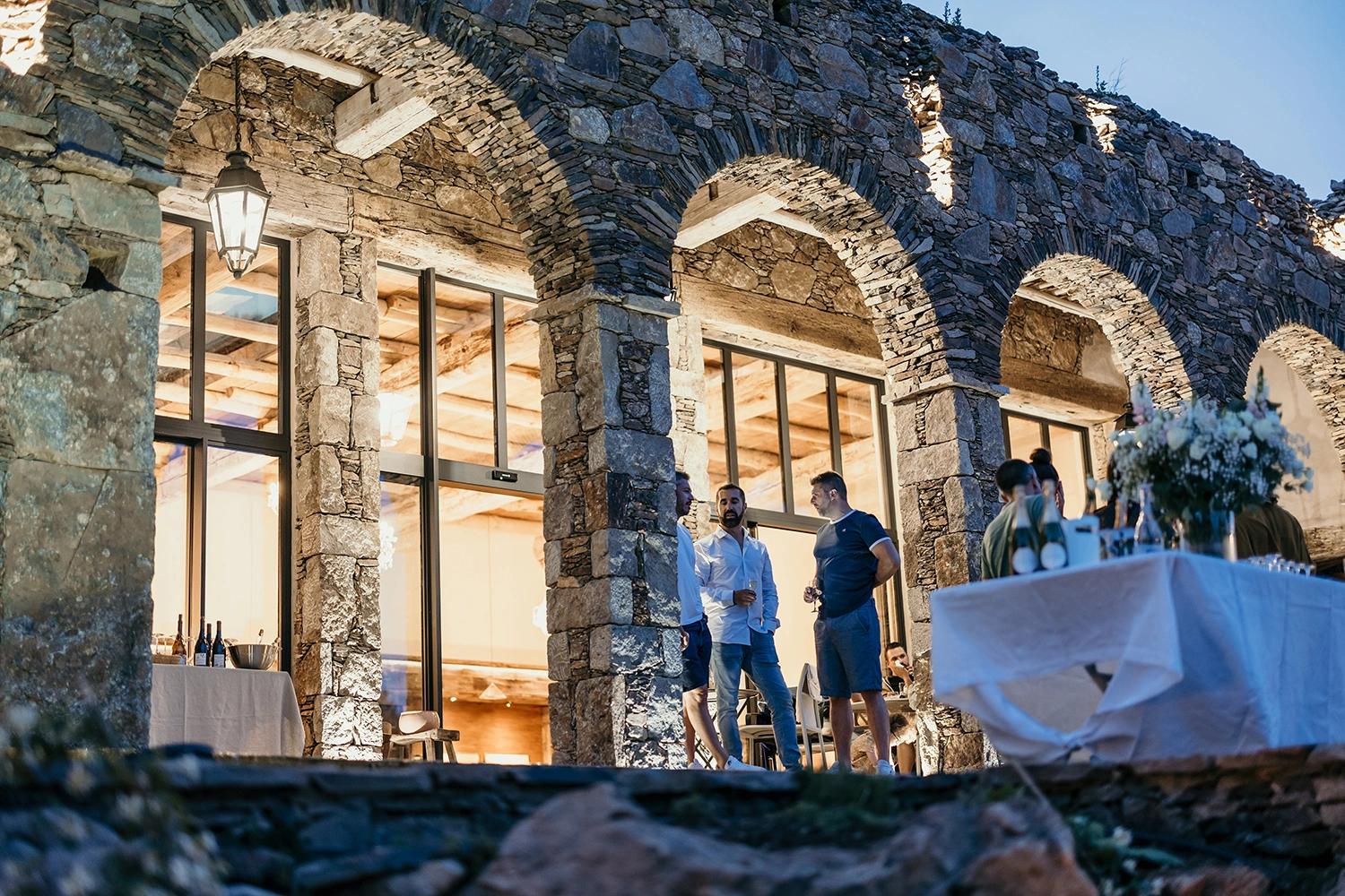 Plusieurs hommes entrain de discuter sur une grande terrasse aux Oliviers de Palombaggia en Corse-du-Sud.